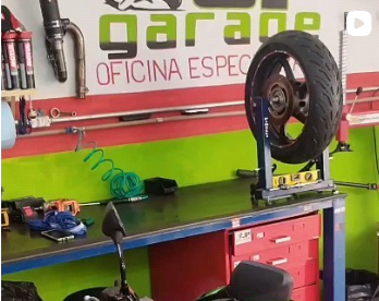 Foto enviada da área de trabalho da JP Garage, com bancada e equipamento para manutenção de motos